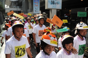 เด็กไทย ใส่ใจสวมหมวกนิรภัย เดินขบวนจากโรงเรียนวัดปทุมวนาราม ผ่านหน้าสยามพารากอน สยามเซ็นเตอร์ Sky Walk สู่หอศิลป์ฯ